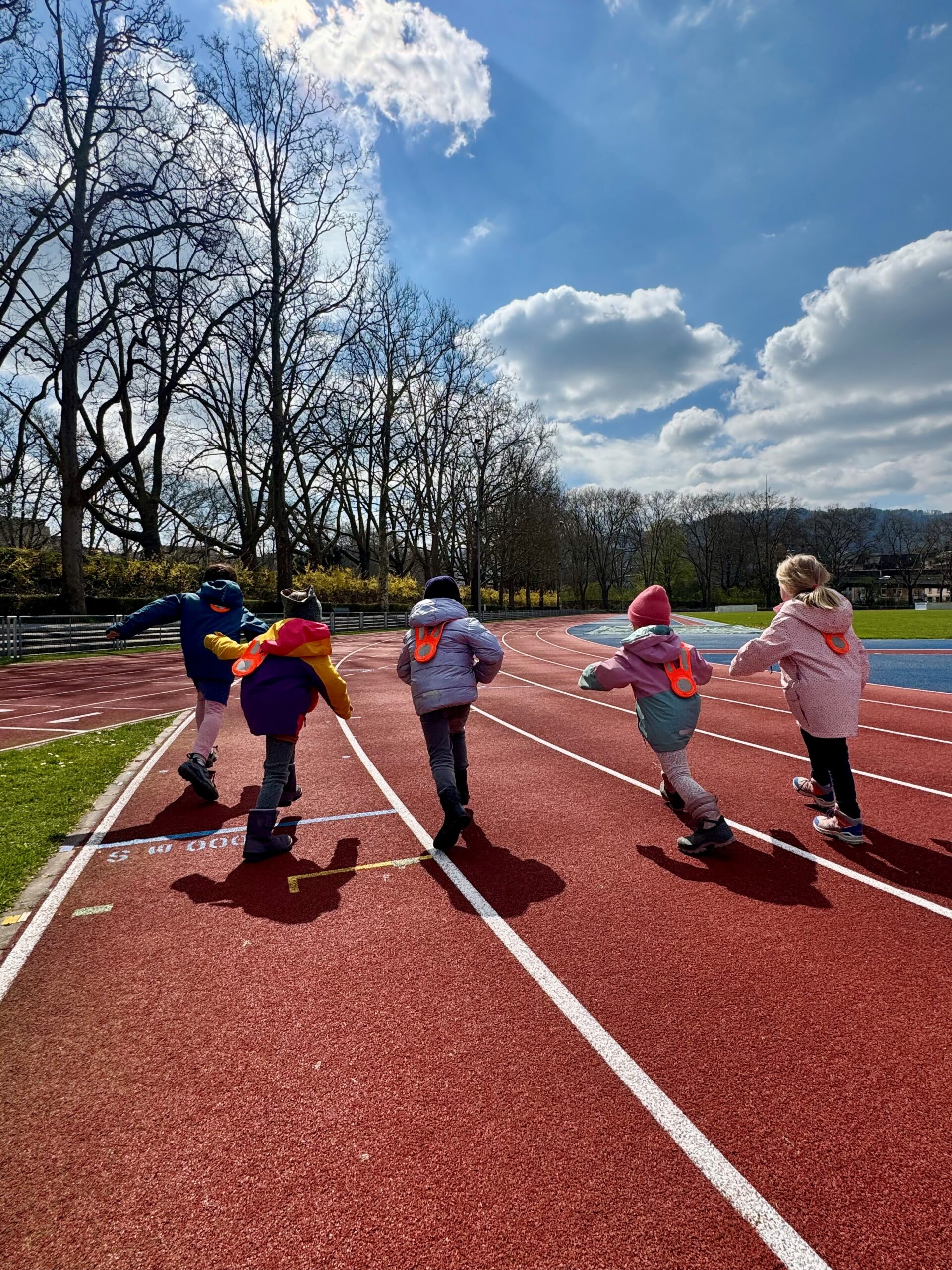 Kinder laufen auf der Bahn